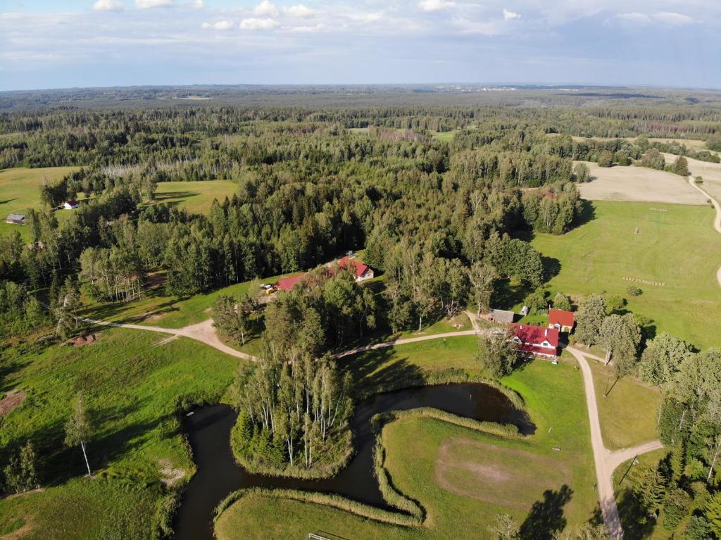 an aerial view of a house on a hill with a river at Klajumi Countryside Cottages & Nature retreat in Kaplava