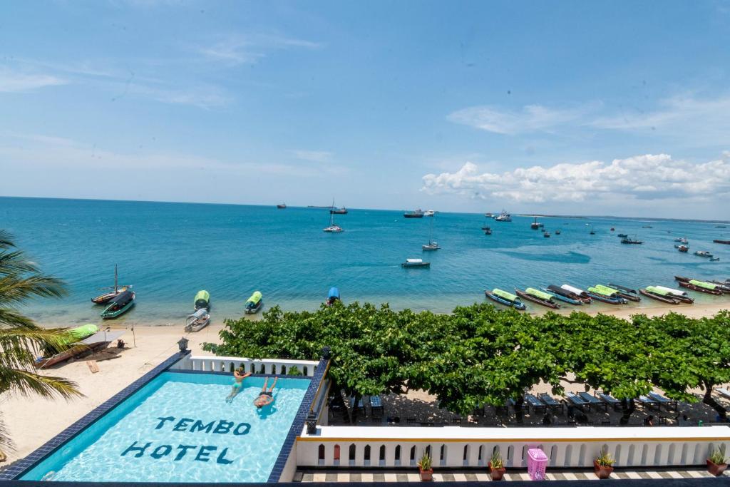 a view of a beach with a swimming pool and the ocean at Tembo House Hotel in Zanzibar City