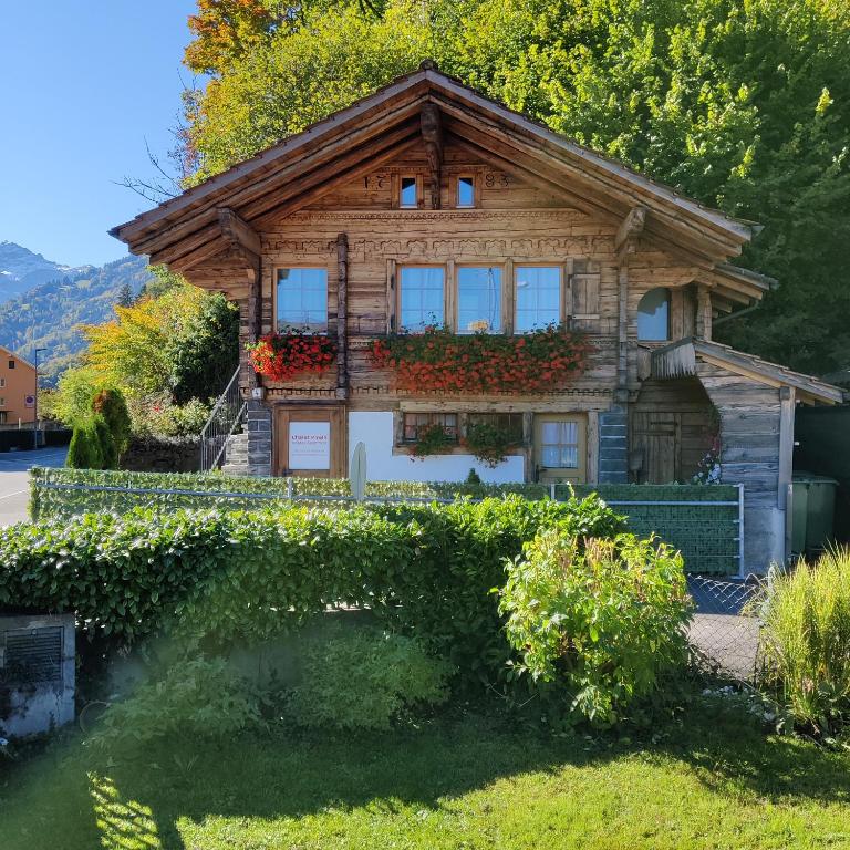 a wooden house with flowers in front of it at Little Chalet Pirelli 1783 in Interlaken