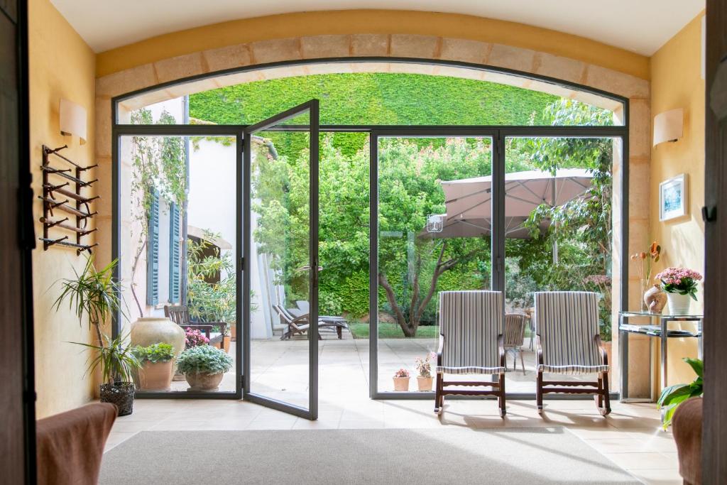 une salle à manger avec des portes coulissantes en verre menant à une terrasse dans l'établissement Hotel Can Moragues Health & Wellness, à Artà