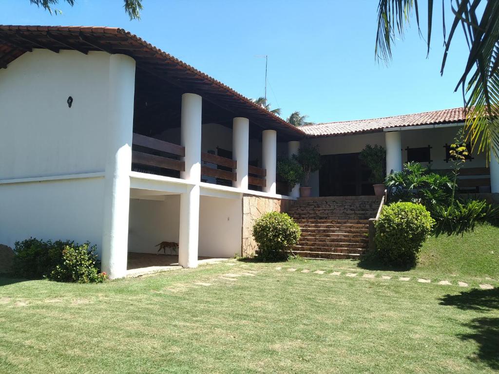 ein weißes Gebäude mit einem Hof davor in der Unterkunft Casa de Praia Pecém in São Gonçalo do Amarante
