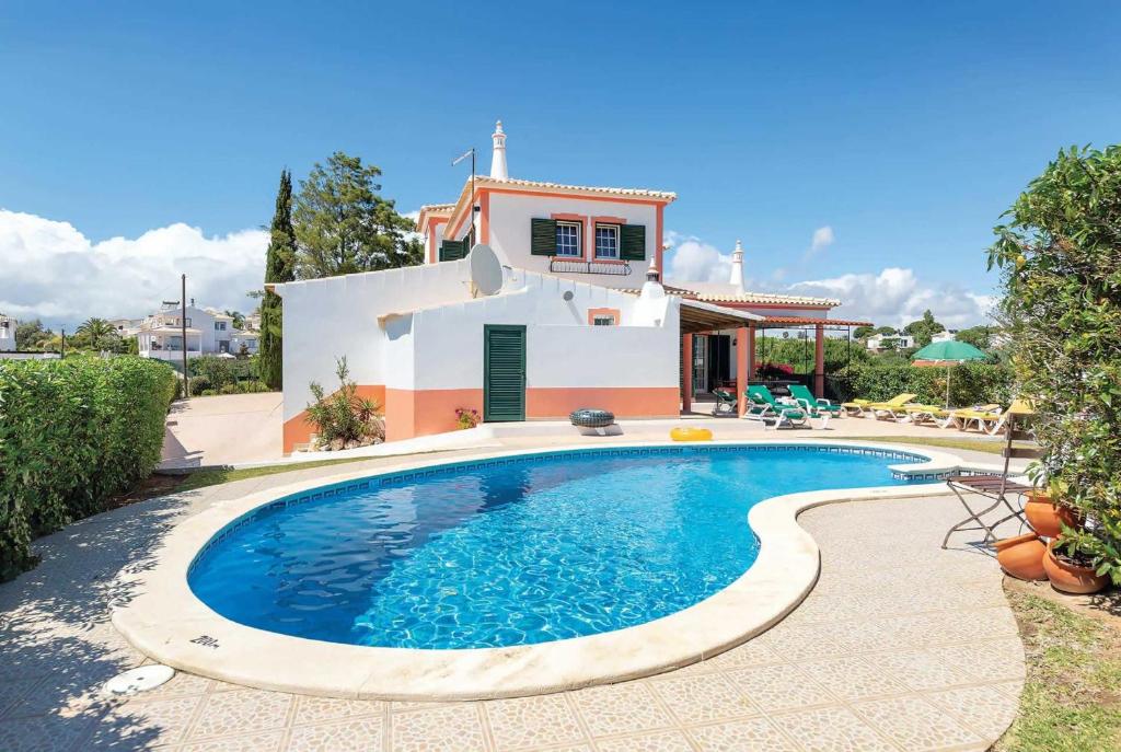 uma villa com piscina em frente a uma casa em Casa Acacia em Carvoeiro
