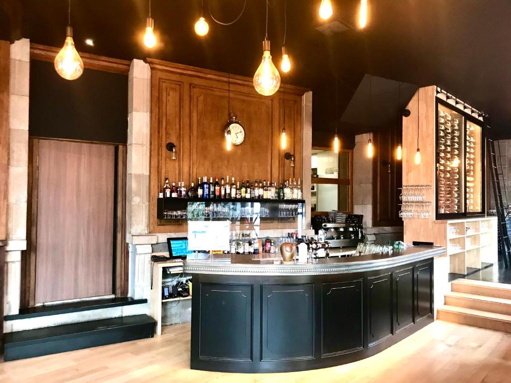 a bar in a restaurant with a counter top at The Originals Boutique, Grand Hôtel Saint-Pierre, Aurillac in Aurillac