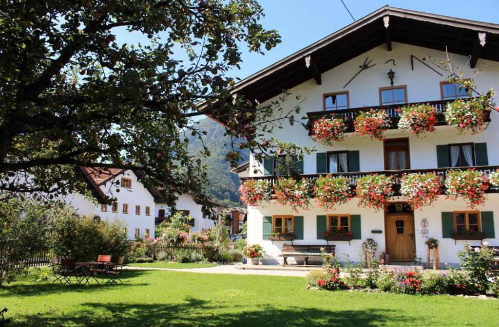 a large white building with flowers on the balcony at Schwaigerhof in Marquartstein