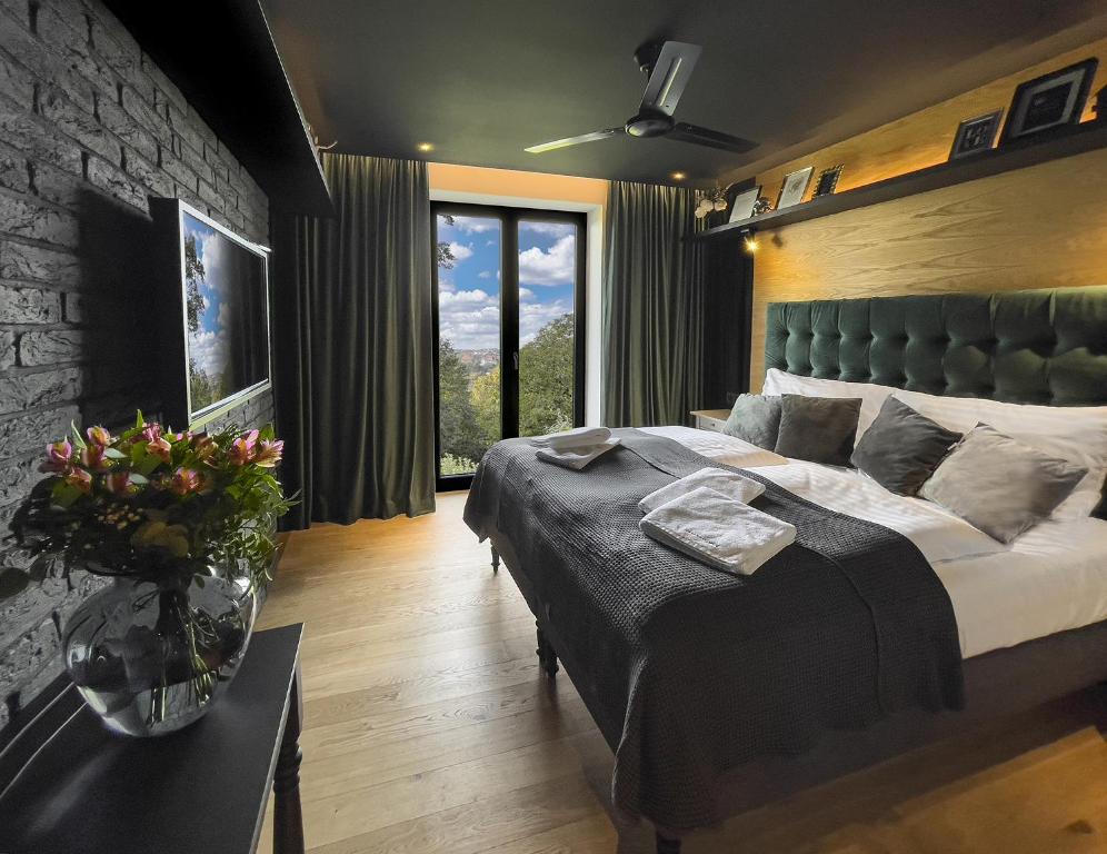a bedroom with a large bed and a large window at Restaurant a Pension u Hradu in Šternberk