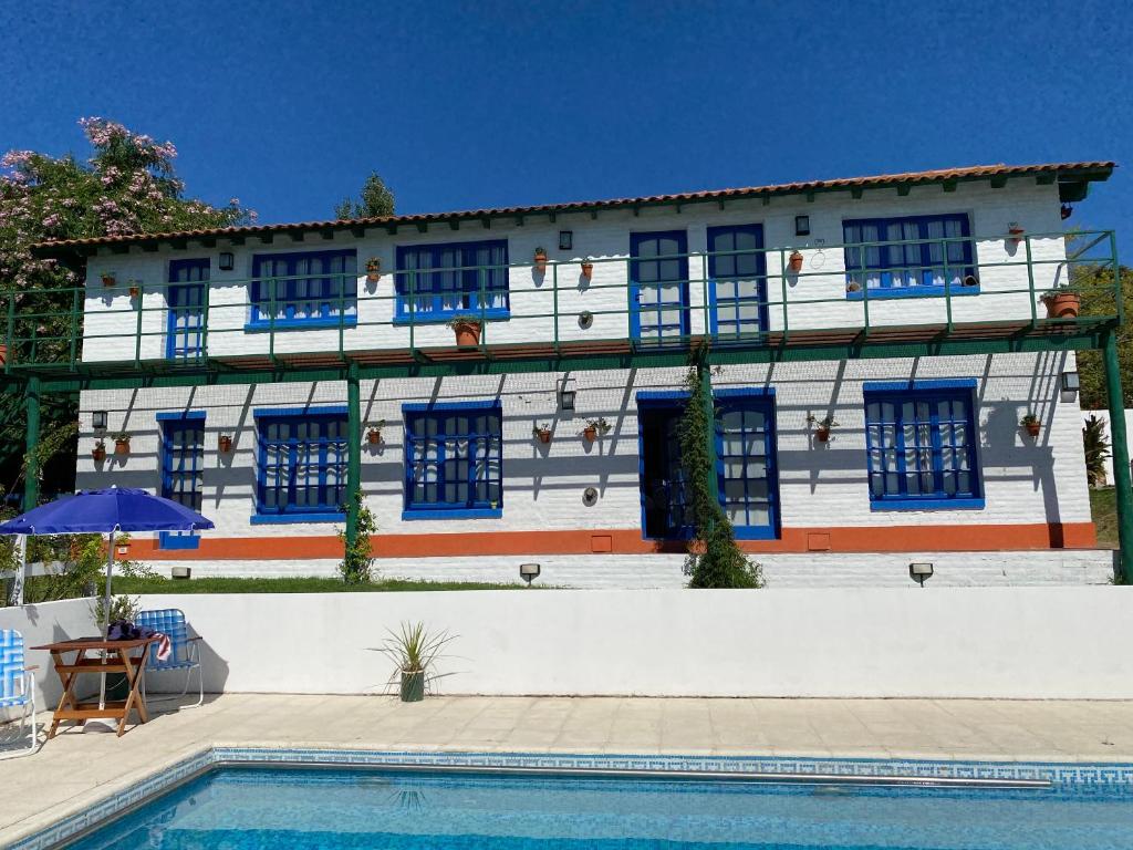 a building with blue windows and a swimming pool at Clara en el Cerro in Tandil