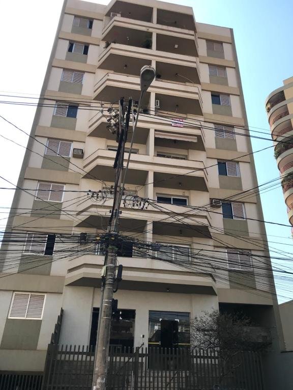 a tall building with power lines in front of it at Apto Alemanha no centro de Ribeirão Preto SP in Ribeirão Preto