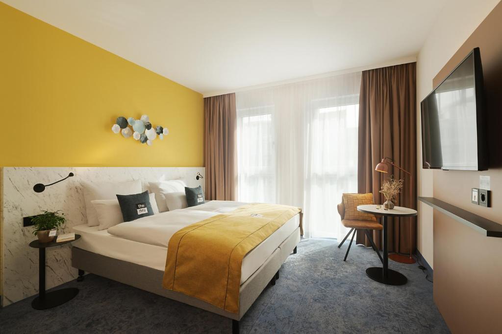 a hotel room with a large bed and a table at the niu Kettle in Stuttgart