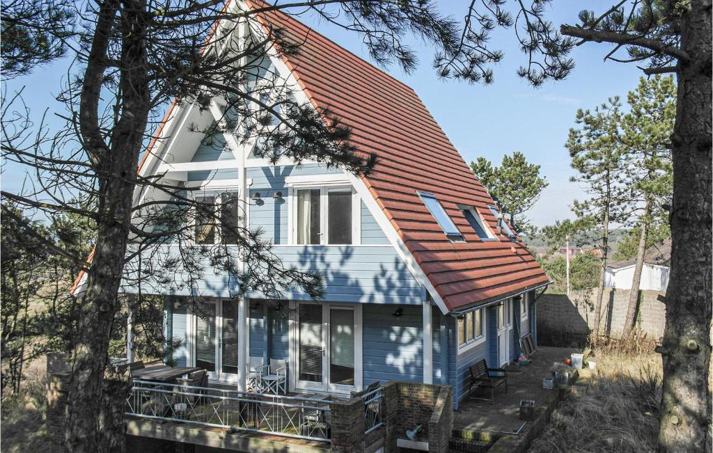 a blue house with an orange roof at Finnhouse in Bergen aan Zee