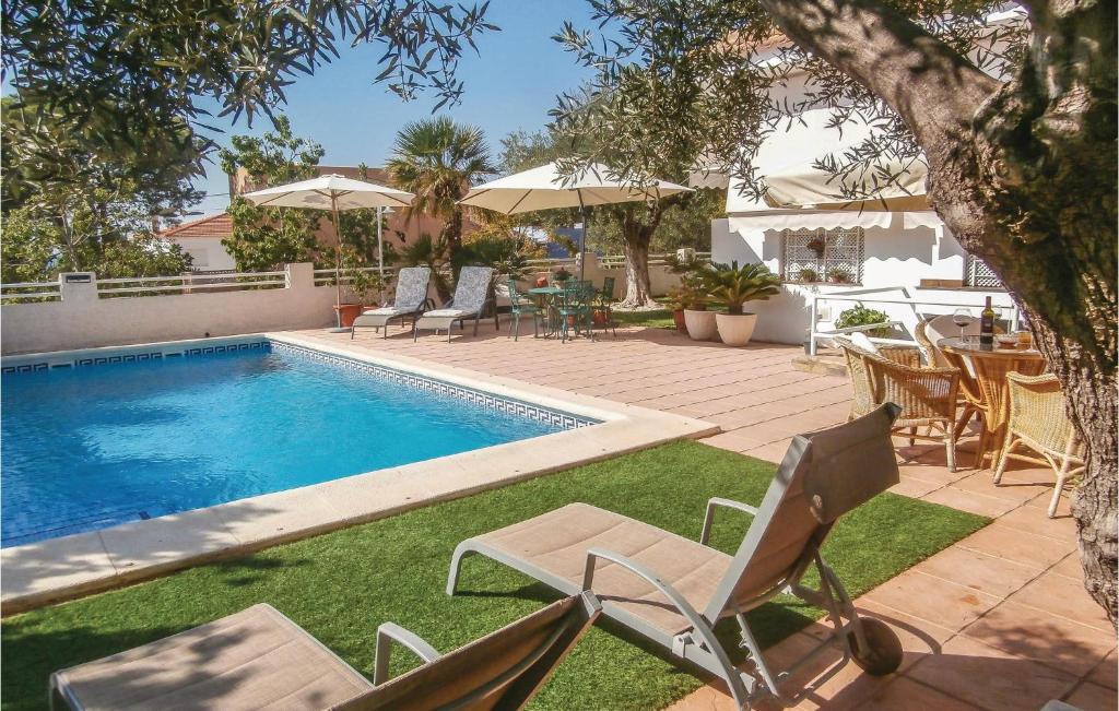 ラ・アソイアにあるBeautiful Apartment In Cartagena With 2 Bedrooms, Wifi And Outdoor Swimming Poolの裏庭(スイミングプール、椅子、テーブル付)