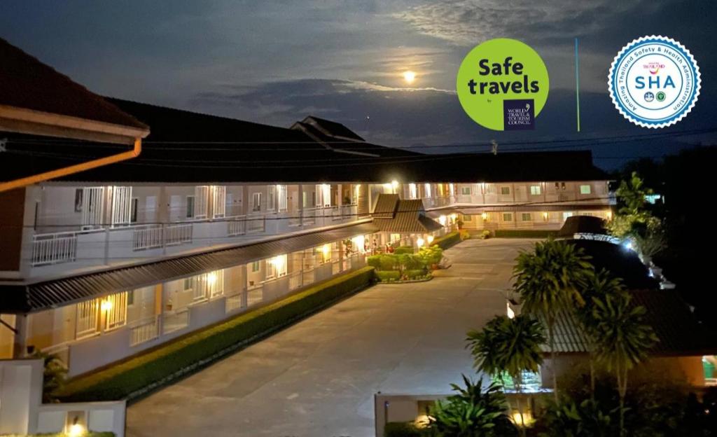 a night view of a hotel with a sign that reads safe travels at Chiangkham Grand Villa - SHA Certified in Chiang Kham
