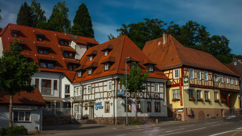 eine Reihe von Häusern mit orangefarbenen Dächern auf einer Straße in der Unterkunft Hotel Bär in Sinsheim