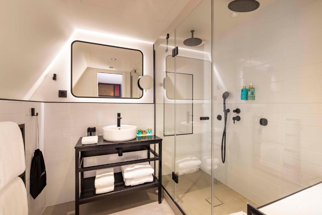 a bathroom with a shower and a sink and a mirror at Le 12 Hôtel in Paris