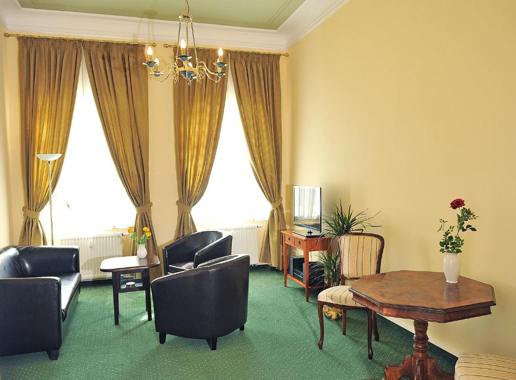 a living room with a table and chairs at Apartmenthaus Stadt Metz in Dresden