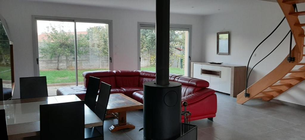 ein Wohnzimmer mit einem roten Sofa und einem Holzofen in der Unterkunft villa neuve ds les monts du lyonnais in Saint-Symphorien-sur-Coise