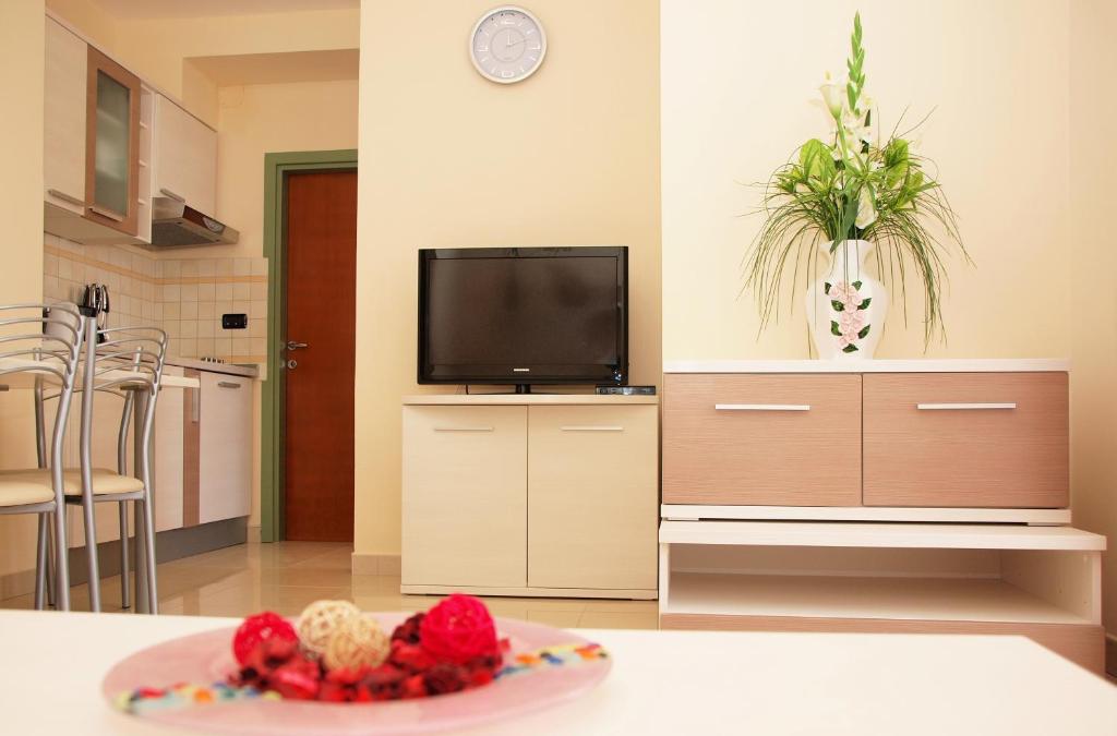 a kitchen with a television and a table with a plate of food at Apartments Medulin - Orijeta in Medulin