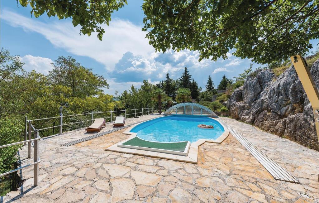 an outdoor swimming pool with a glass dome on a stone patio at Amazing Home In Siveric With 3 Bedrooms, Wifi And Outdoor Swimming Pool in Siverić