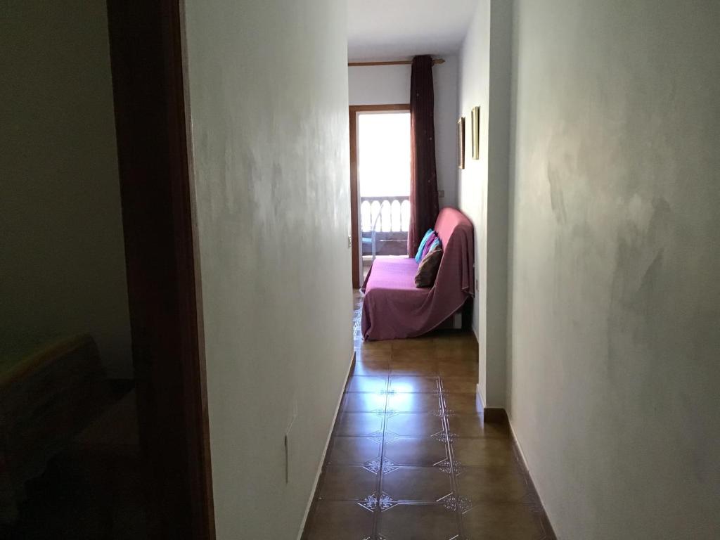a hallway with a room with a couch and a window at Apartamentos Playamar in La Playa Calera