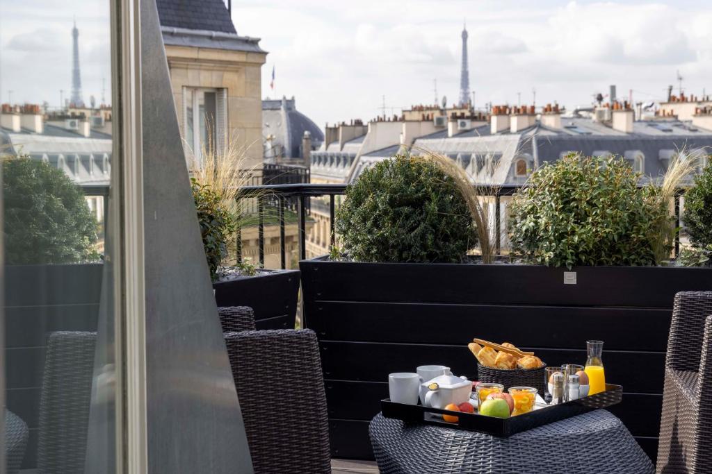 un vassoio di cibo su un tavolo sul balcone di Le 12 Hôtel a Parigi