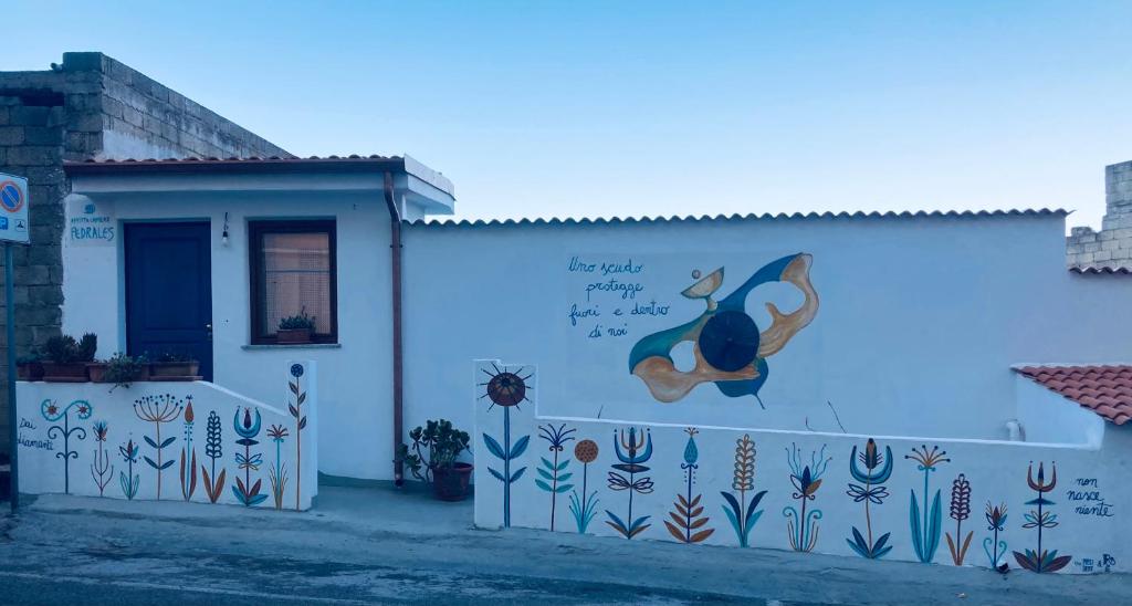 un edificio con un mural en el costado en Pedrales Orgosolo en Orgosolo