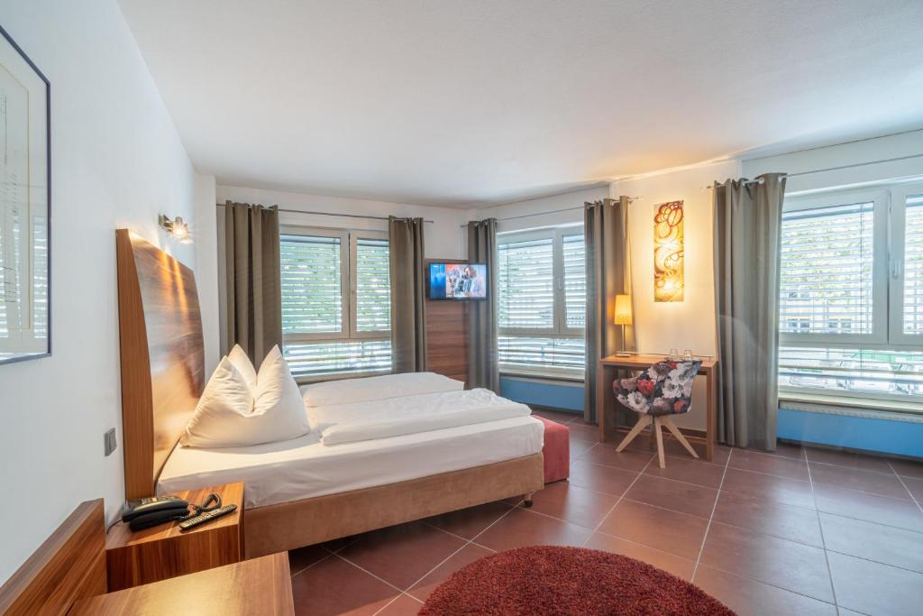 ein Schlafzimmer mit einem Bett in einem Zimmer mit Fenstern in der Unterkunft Hotel Schottenhof in Mainz