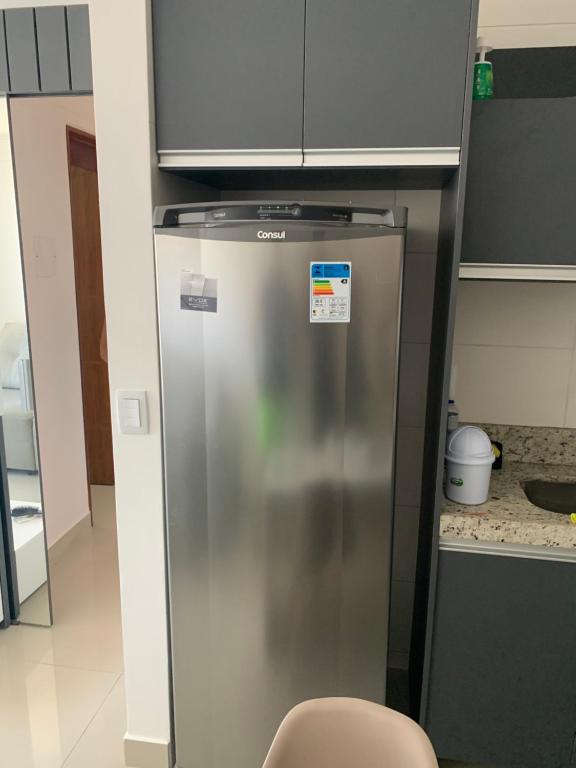 a stainless steel refrigerator in a kitchen with a microwave at FLAt COMPLETO BEIRA MAR in Cabedelo