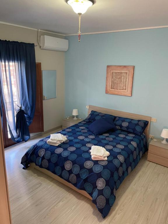 a bedroom with a blue bed with two towels on it at B&B Fiume in Morino