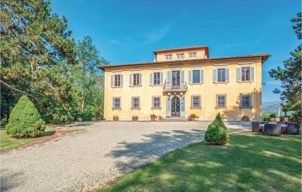 a large yellow house with a large driveway at Villa Di Collina in Vicchio