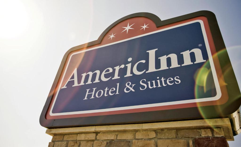 um sinal para um hotel e suites americanos em AmericInn by Wyndham McAlester em McAlester