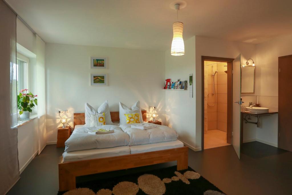 1 dormitorio con 1 cama con sábanas y almohadas blancas en Studio 14/2 en Göppingen