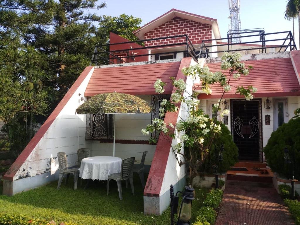 a house with a table and chairs in the yard at We have wonderful villa at Shantiniketan. in Shānti Niketan