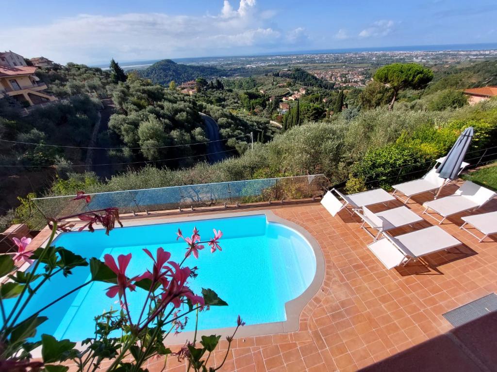 einen Pool mit Stühlen und Bergblick in der Unterkunft Villa Jasmine con vista mare e piscina in Corsanico-Bargecchia