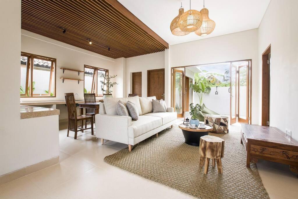 a living room with a white couch and a table at rainNan Villa- Near Bali Safari in Gianyar