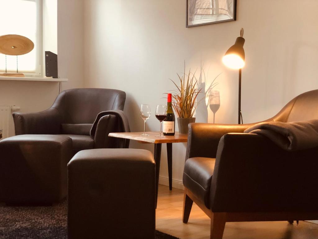 ein Wartezimmer mit Stühlen und einem Tisch mit Weingläsern in der Unterkunft Altstadthus-gemütliches Ferienhaus mit Gärtchen in Friedrichstadt