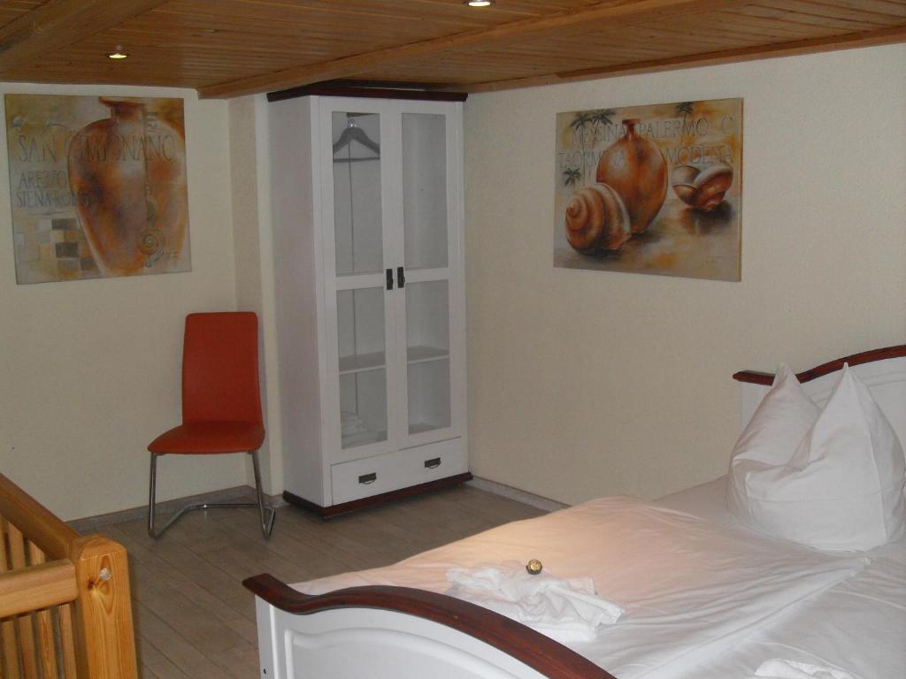 een slaapkamer met een bed en een rode stoel bij Wohnen Im Topf in Quedlinburg