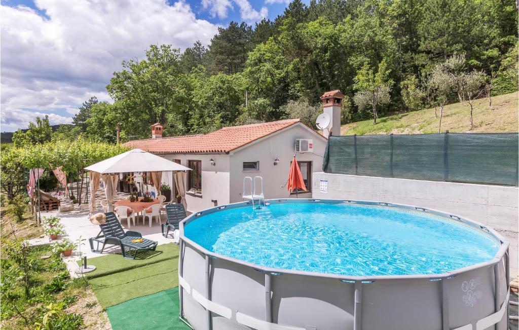a swimming pool on a yard with a house at 2 Bedroom Cozy Home In Kostrcani in Kostrčani