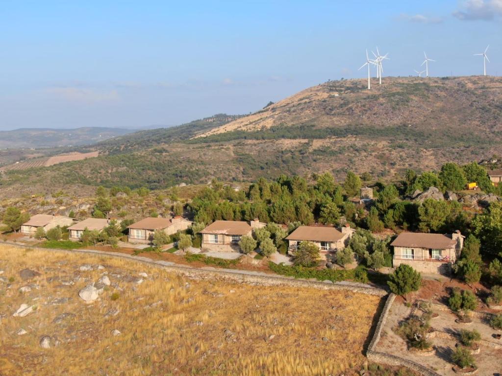 une vue aérienne d'une maison avec des éoliennes sur une colline dans l'établissement Montanhas do Douro, à Paredes da Beira