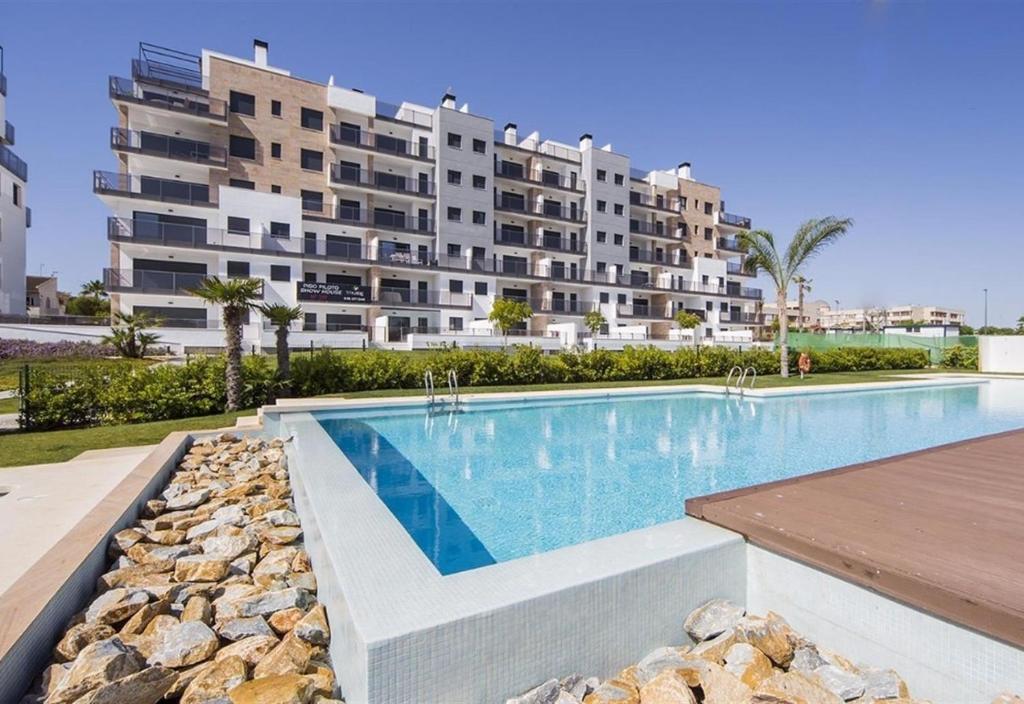 a swimming pool in front of a large apartment building at Apartment in Mil Palmeras in Pilar de la Horadada
