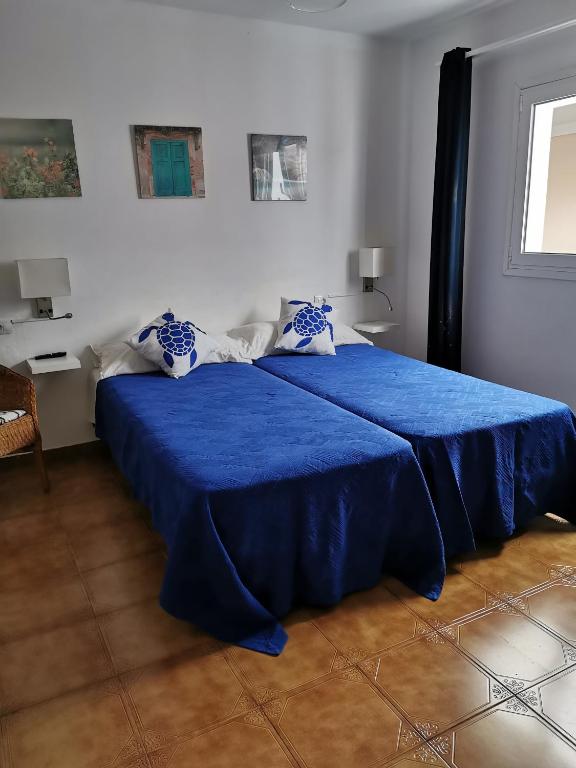 a bedroom with two beds with blue sheets at Apartamentos Playamar in La Playa Calera
