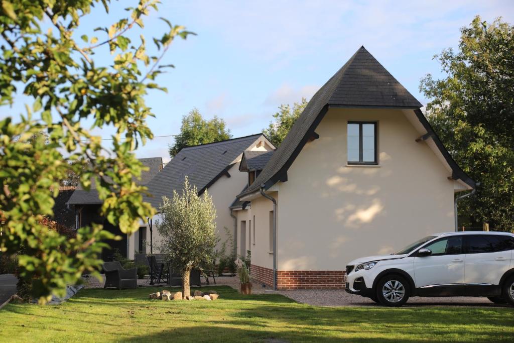 un coche blanco estacionado frente a una casa en "Chez Michel " Les Gîtes de Séry, en Bouillancourt-en-Séry