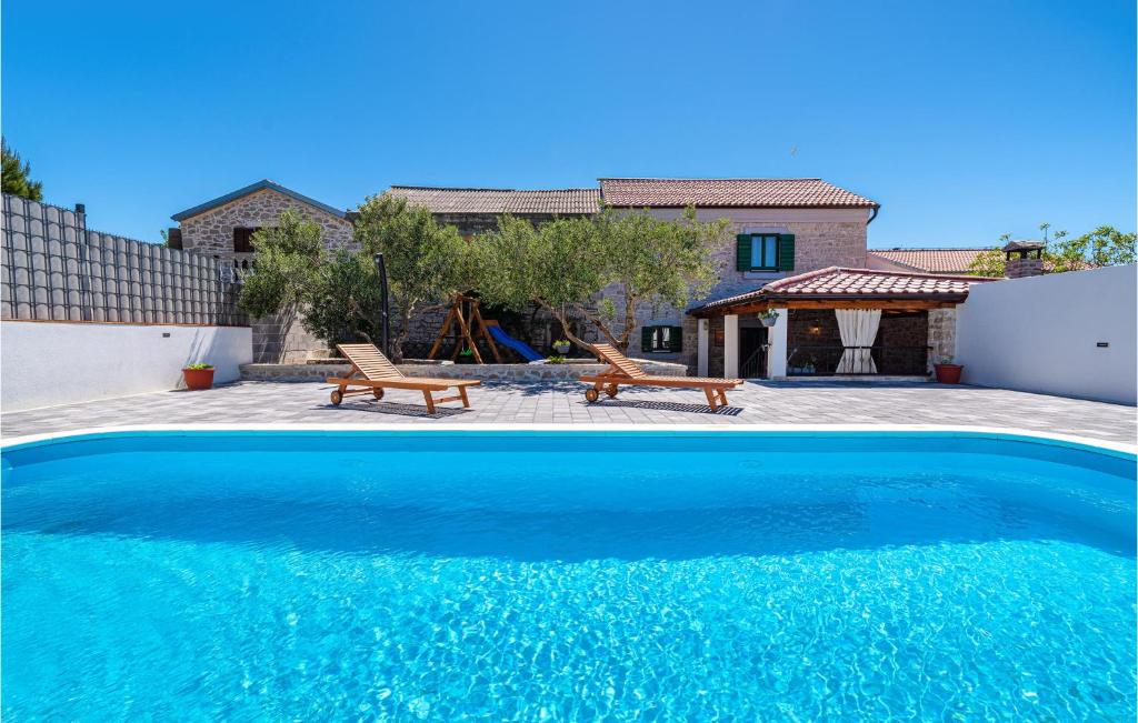 une piscine bleue en face d'une maison dans l'établissement 4 Bedroom Awesome Home In Drage, à Drage