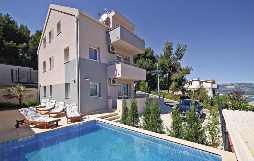 ein Haus mit einem Pool neben einem Gebäude in der Unterkunft Awesome Home In Zedno With Outdoor Swimming Pool in Trogir