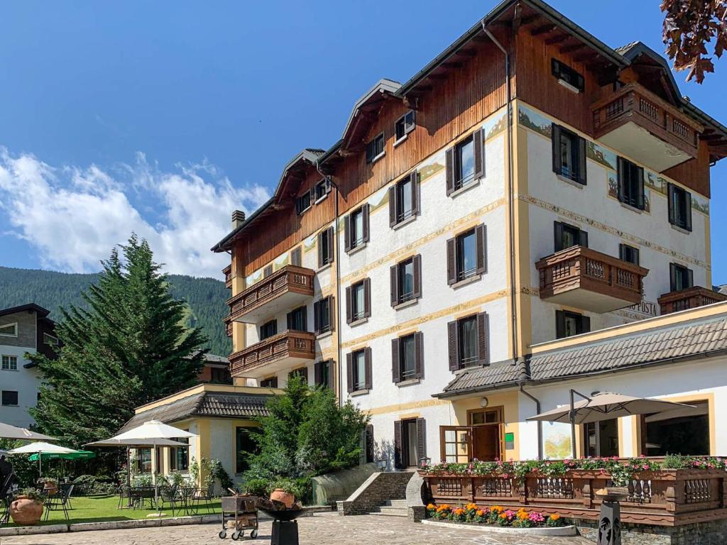 a large building with benches in front of it at Hotel Posta in Aprica