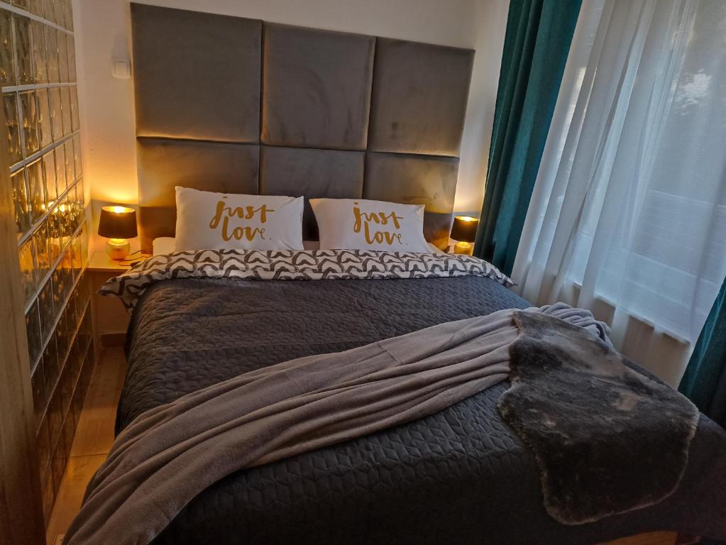a bedroom with a large bed with two pillows at Apartment Close2park *** in Čakovec