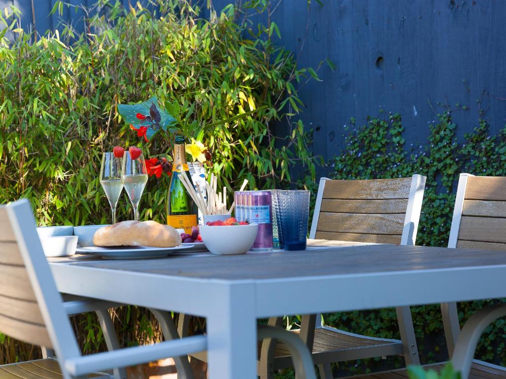 een blauwe tafel met een bord eten en wijnglazen bij Trengoff in St Ives