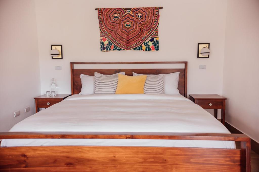 a bedroom with a large bed with a wooden headboard at Ojala in Antigua Guatemala