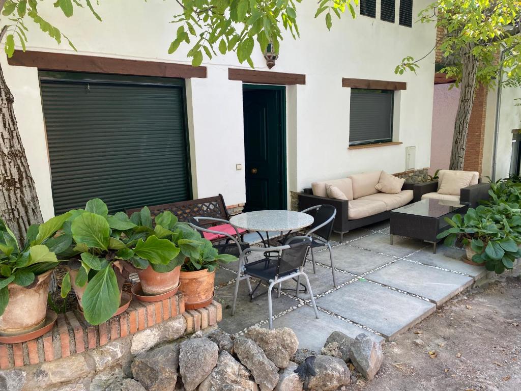 een patio met een tafel en stoelen en een bank bij Casa Rural 3 en un fantástico legado in Alfacar