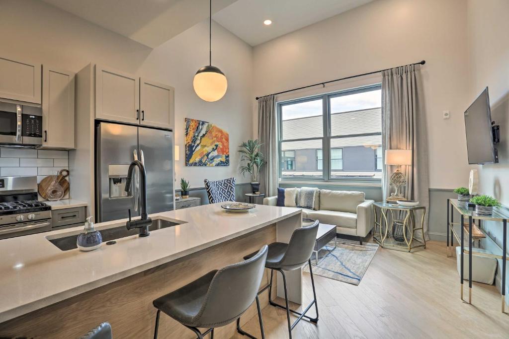 a kitchen and living room with a counter and chairs at Modern Downtown Birmingham Condo with Rooftop Access in Birmingham