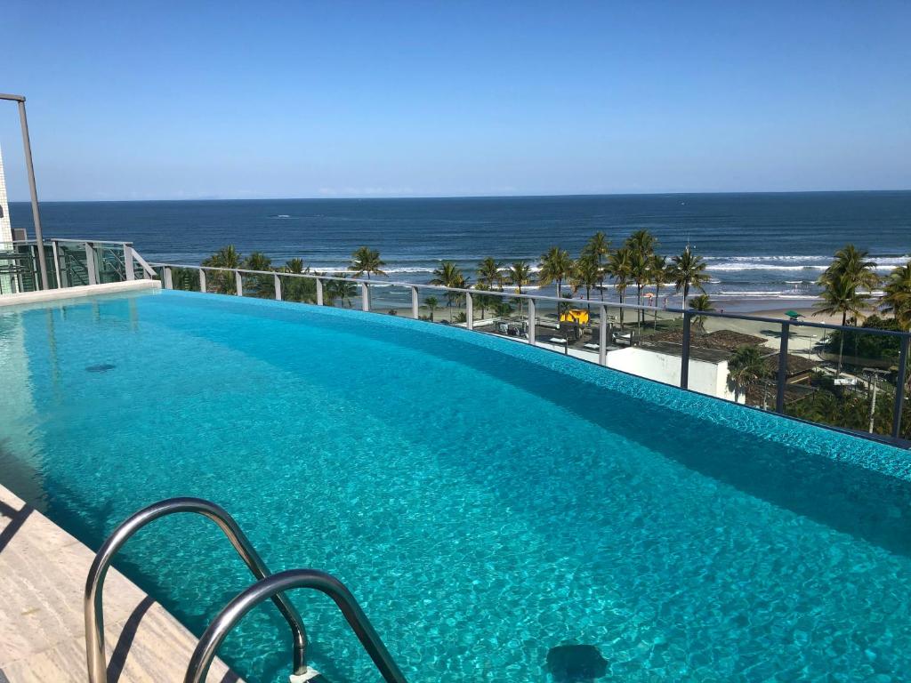 a swimming pool with a view of the ocean at Riviera front beach - Ed San Sebastian in Riviera de São Lourenço