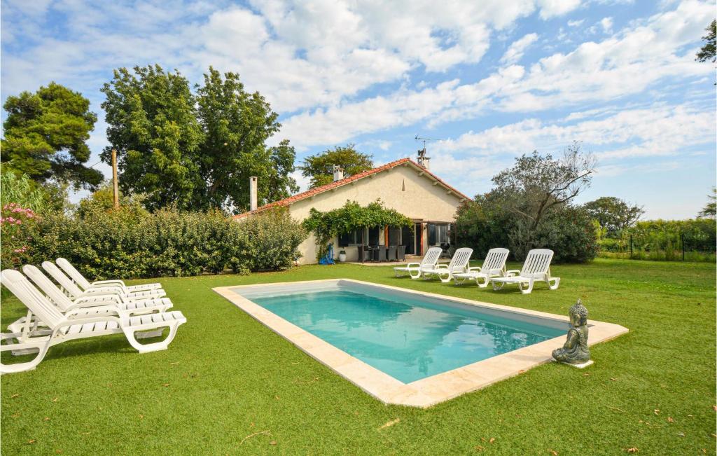 un patio con una piscina con sillas y una casa en Le Mas Neuf, en Le Sambuc